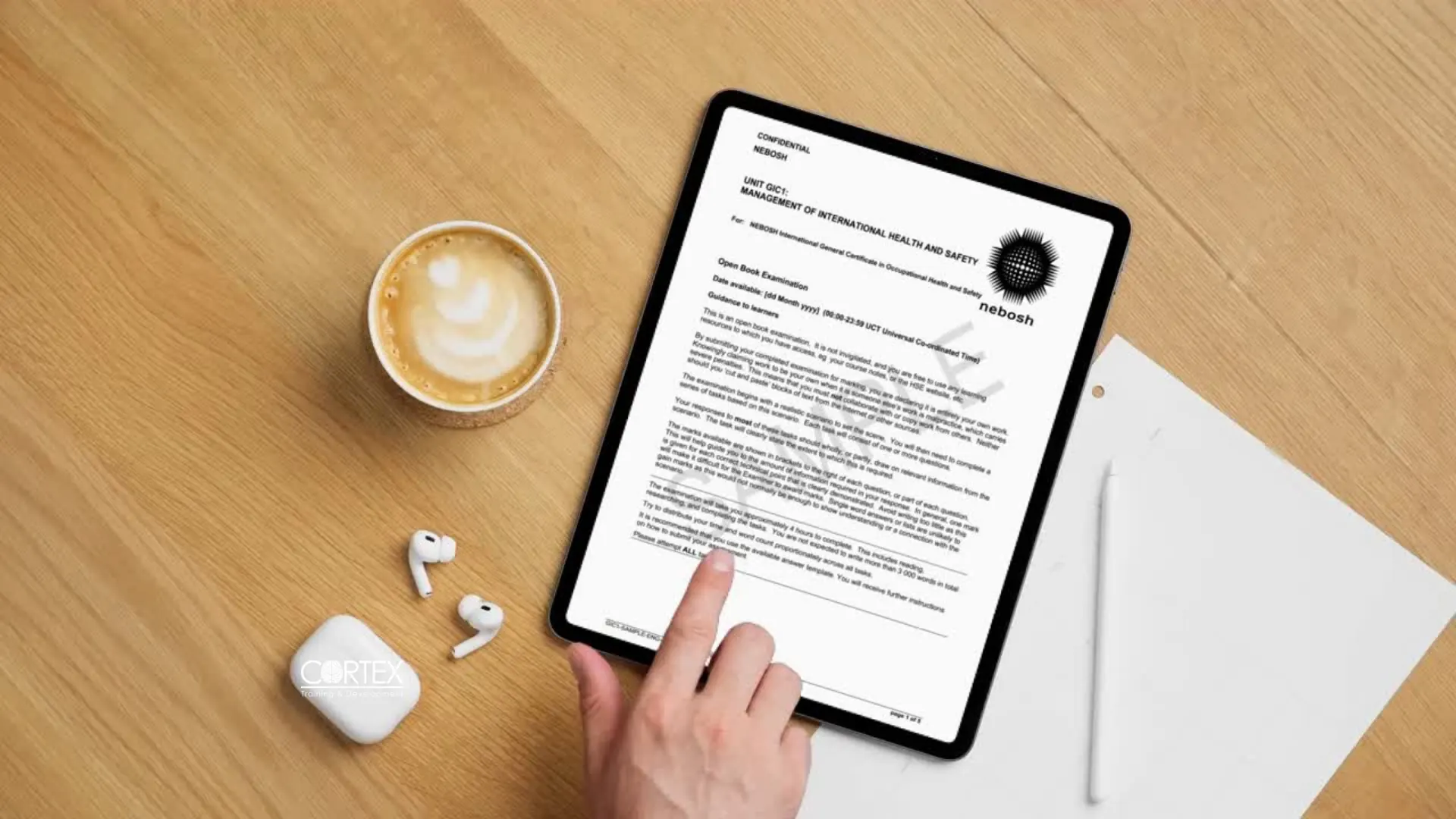 An open book examination paper open on a tablet at a desk